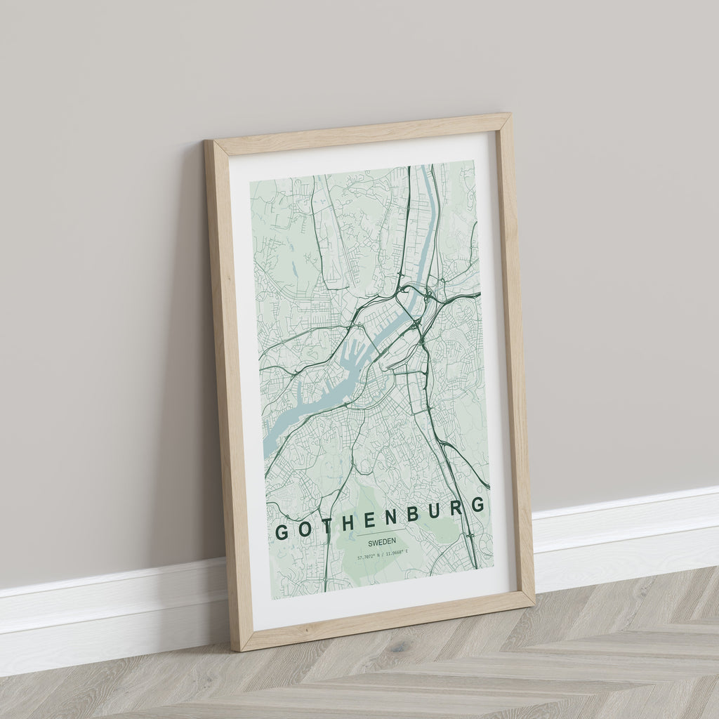Gothenburg map print in the Forest theme in a light wooden frame leaning against a pale wall
