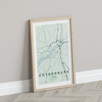 Gothenburg map print in the Forest theme in a light wooden frame leaning against a pale wall