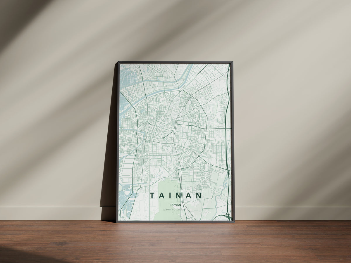 Tainan, Taiwan map print in the Forest theme in a black frame on a wooden surface against a pale wall