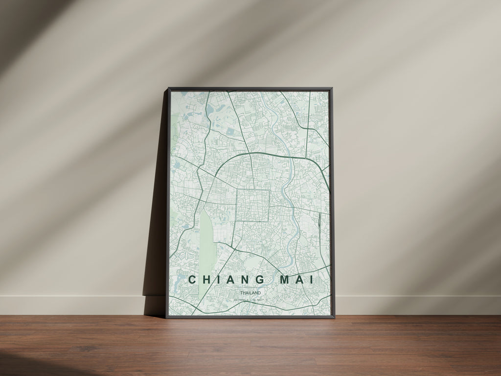 Chiang Mai, Thailand map print in the Forest theme in a black frame on a wooden surface against a pale wall