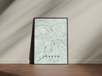 London map print in the Forest theme in a black frame beside a pale wall and wooden floor