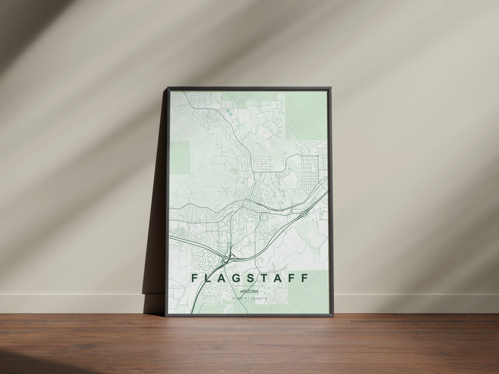 Flagstaff map print in the Forest theme in a black frame on a wooden surface against a pale wall