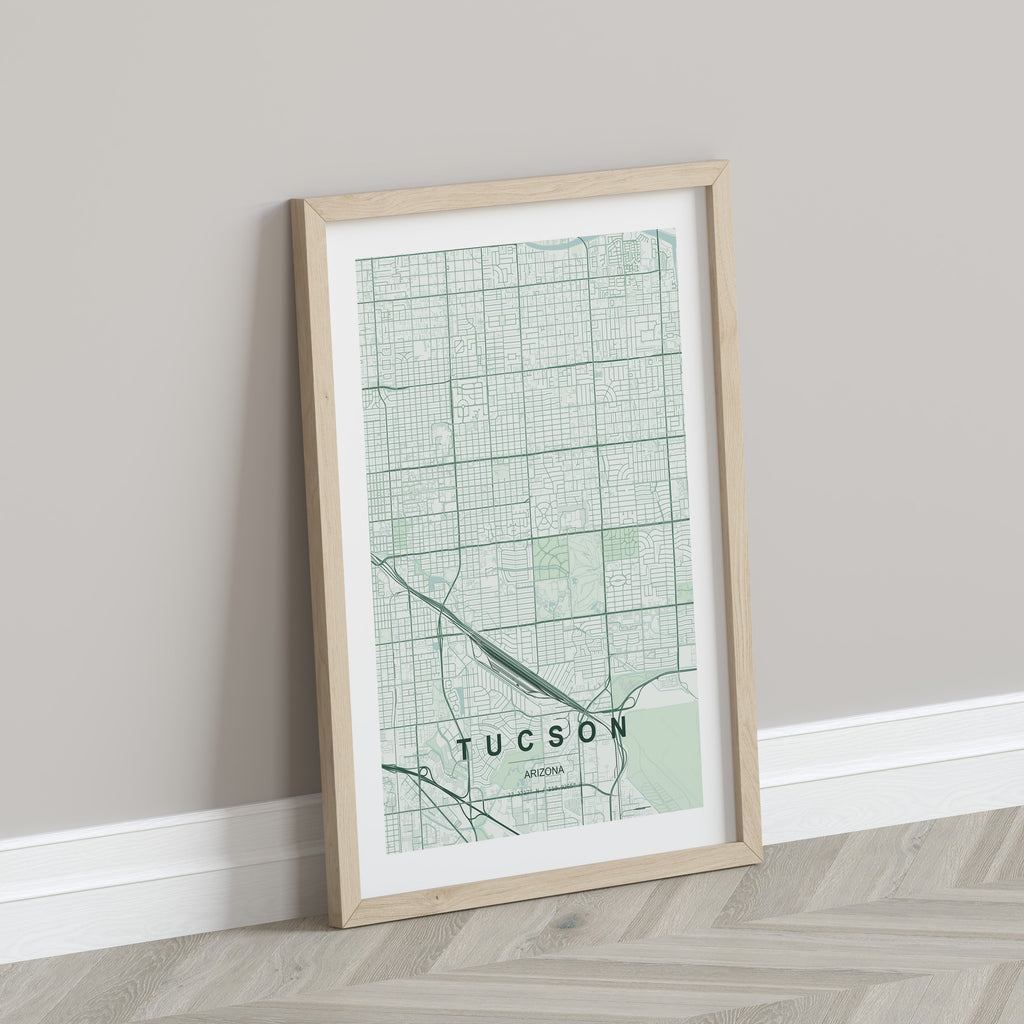 Tucson map print in the Forest theme in a light wooden frame leaning against a pale wall