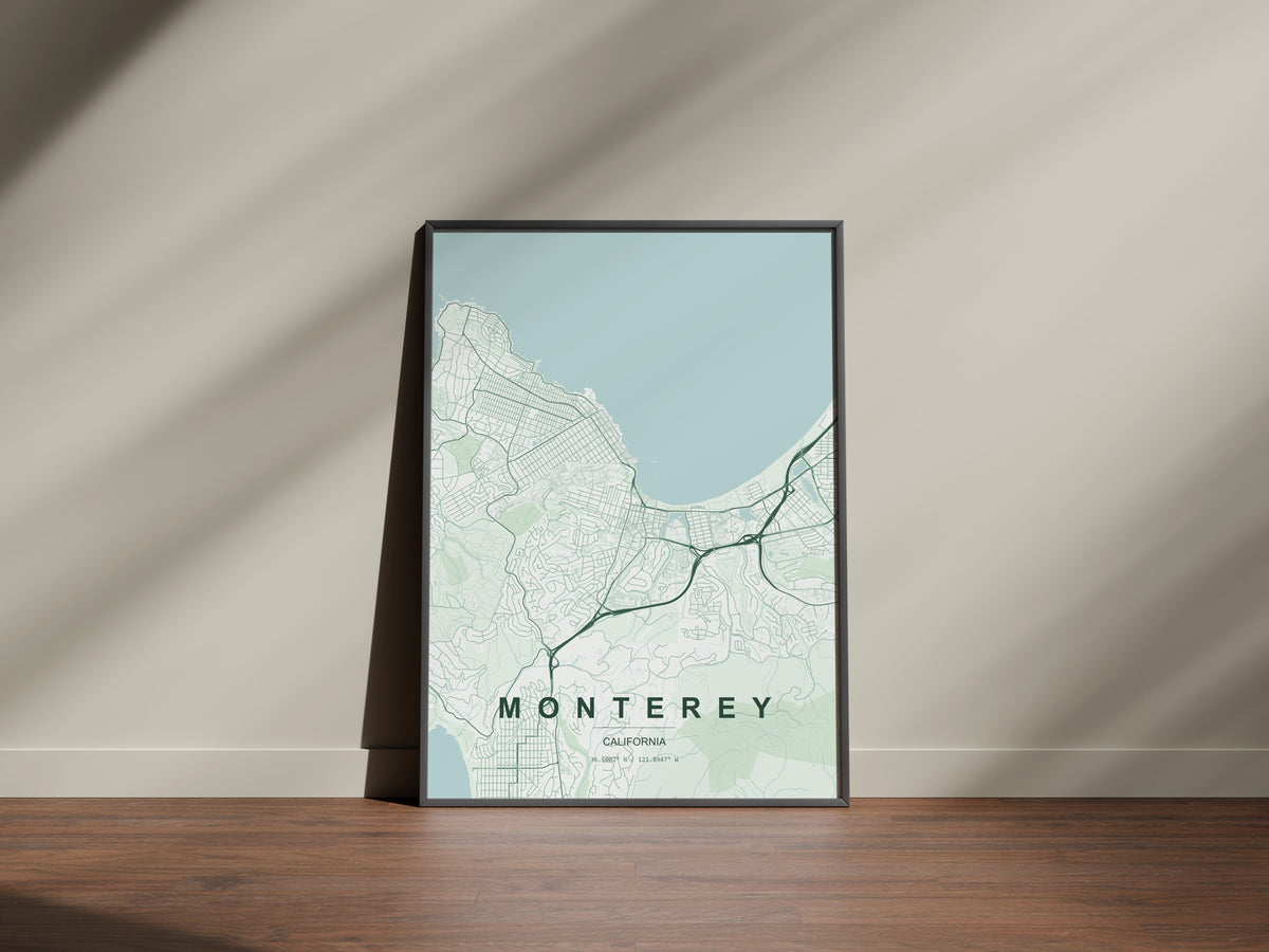 Monterey map print in the Forest theme in a black frame on a wooden surface against a pale wall