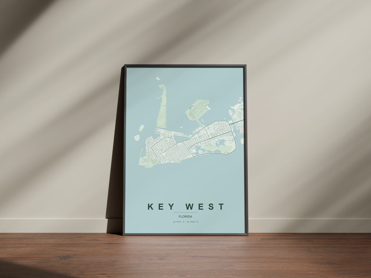 Key West map print in the Forest theme in a black frame on a wooden surface against a pale wall