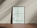 Grand Rapids map print in the Forest theme in a black frame on a wooden surface against a pale wall