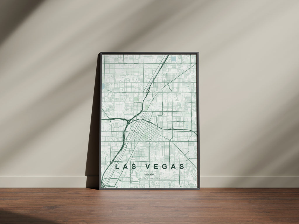 Las Vegas map print in the Forest theme in a black frame on a wooden surface against a pale wall