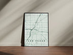 Las Vegas map print in the Forest theme in a black frame on a wooden surface against a pale wall