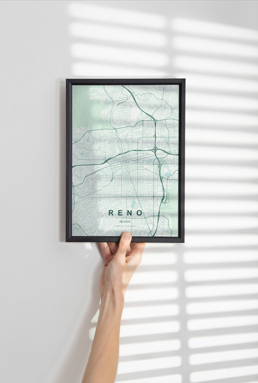 Reno map print in the Forest theme in a black frame held against a pale wall