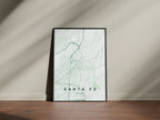 Santa Fe map print in the Forest theme in a black frame on a wooden surface against a pale wall