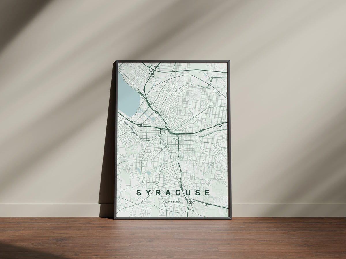 Syracuse map print in the Forest theme in a black frame on a wooden surface against a pale wall