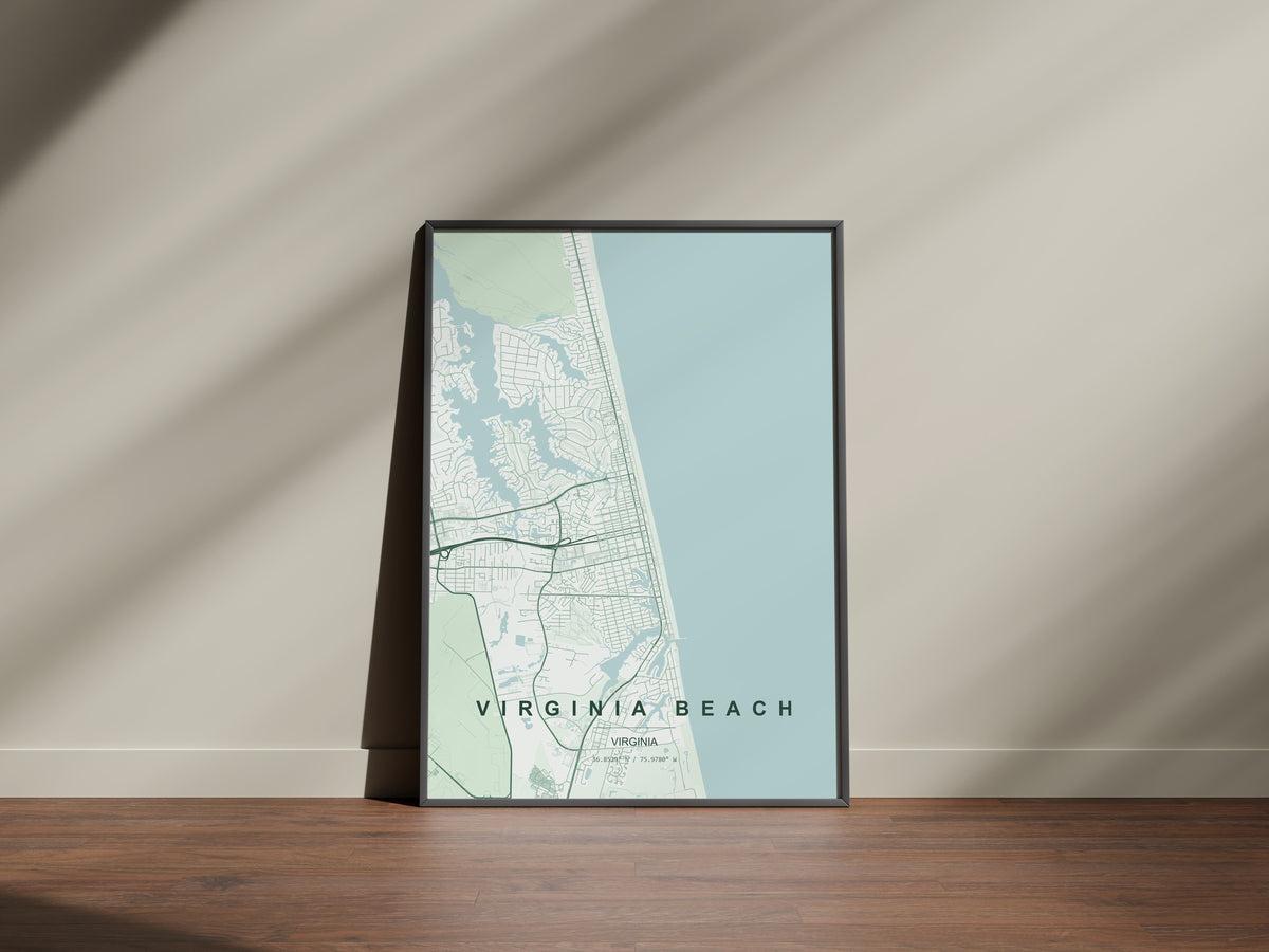 Virginia Beach map print in the Forest theme in a black frame on a wooden surface against a pale wall