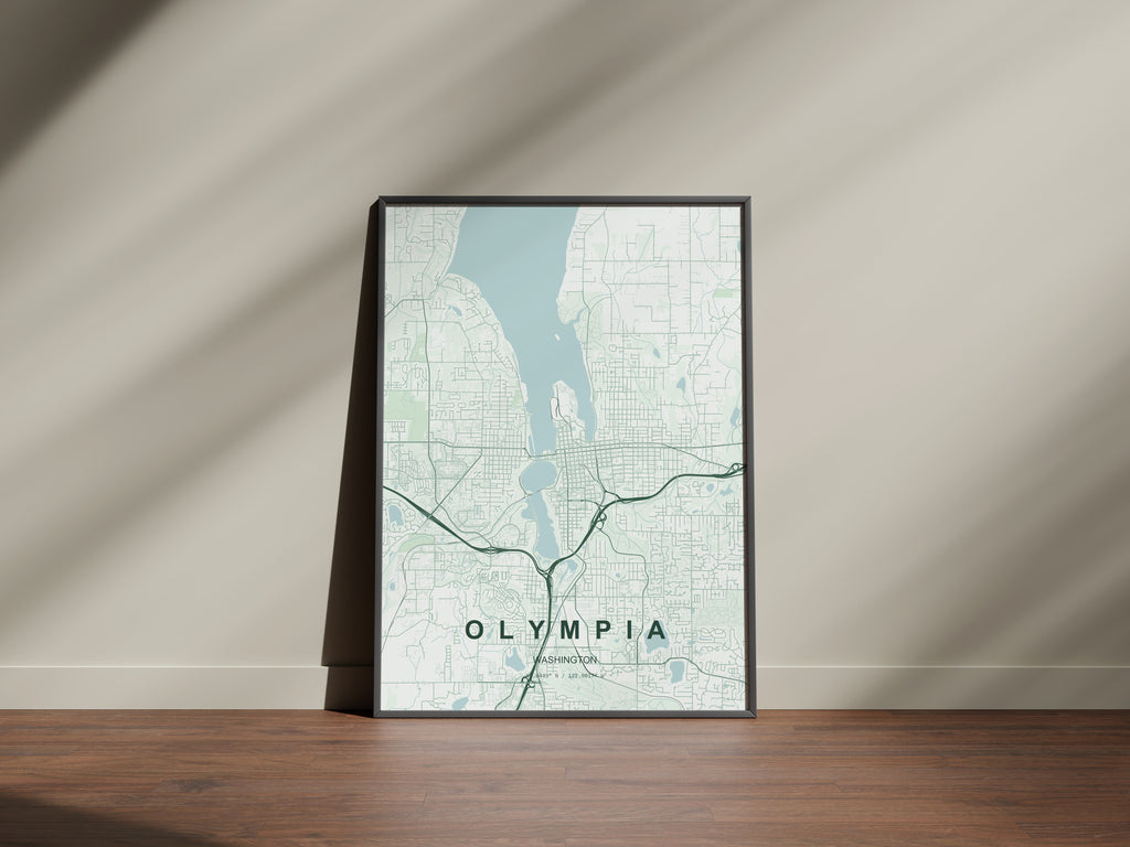 Olympia map print in the Forest theme in a black frame on a wooden surface against a pale wall