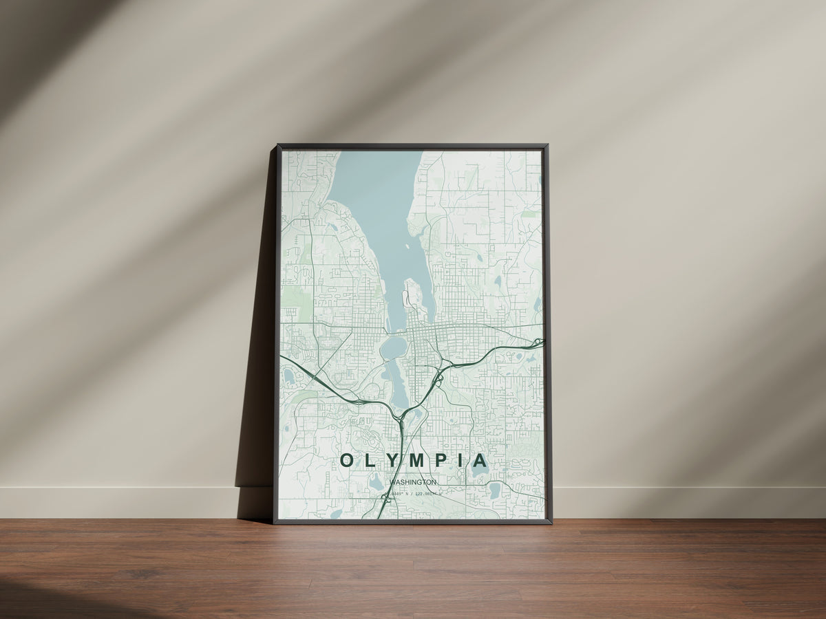 Olympia map print in the Forest theme in a black frame on a wooden surface against a pale wall