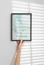 Olympia map print in the Forest theme in a black frame held against a pale wall