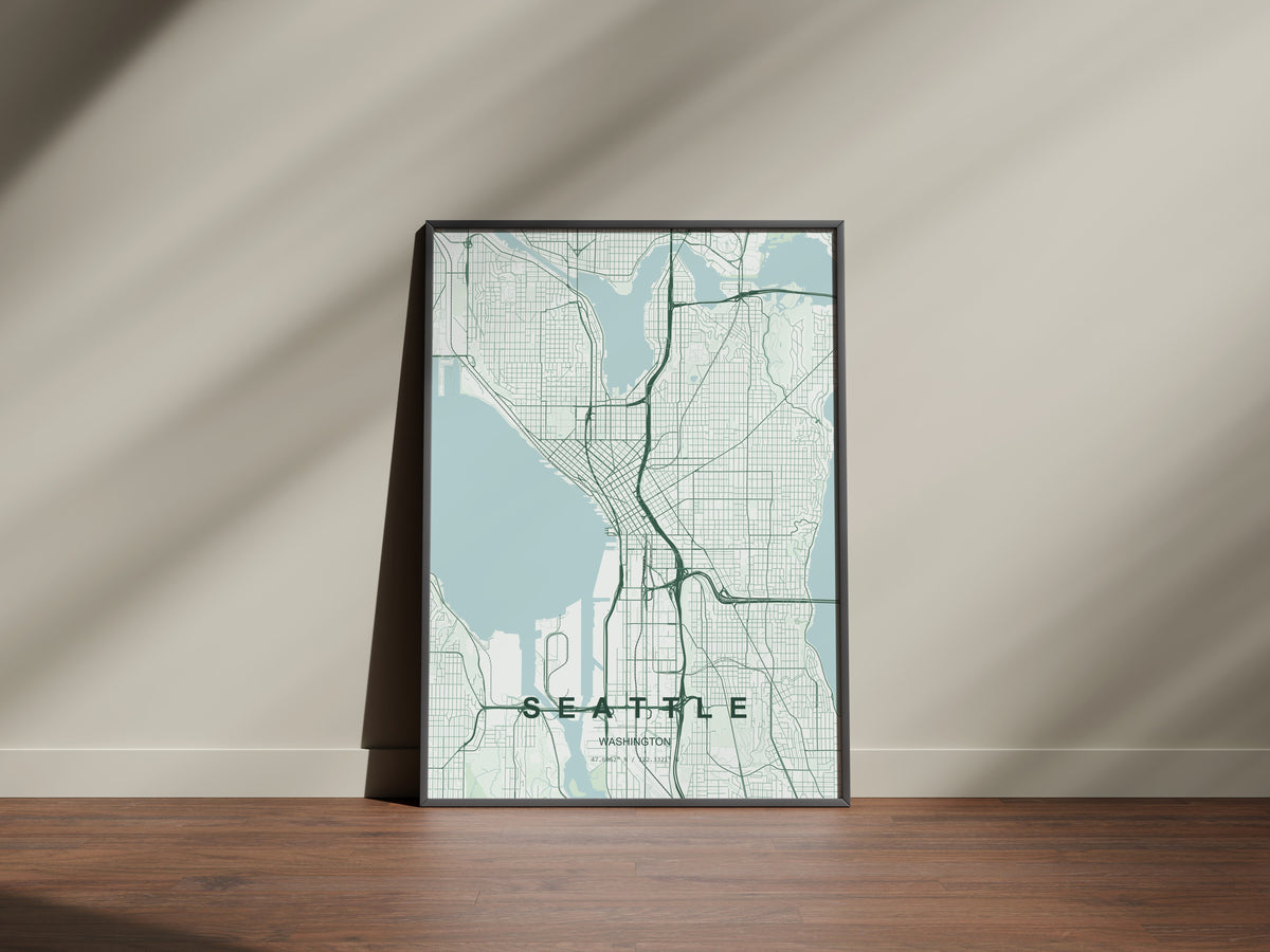 Seattle map print in the Forest theme in a black frame on a wooden surface against a pale wall
