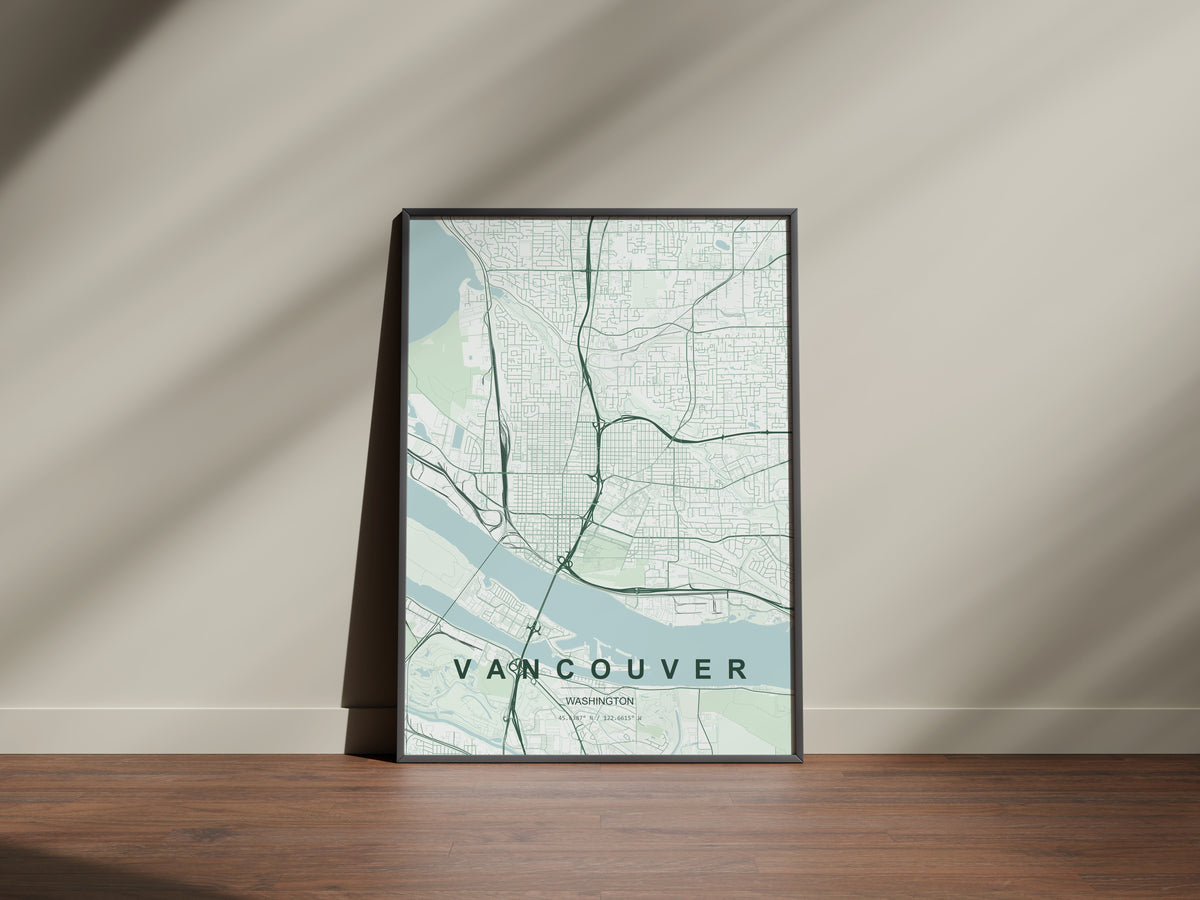 Vancouver map print in the Forest theme in a black frame on a wooden surface against a pale wall