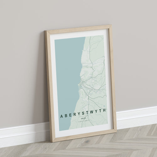 Aberystwyth, Wales, United Kingdom map print in the Forest theme in a light wooden frame leaning against a pale wall